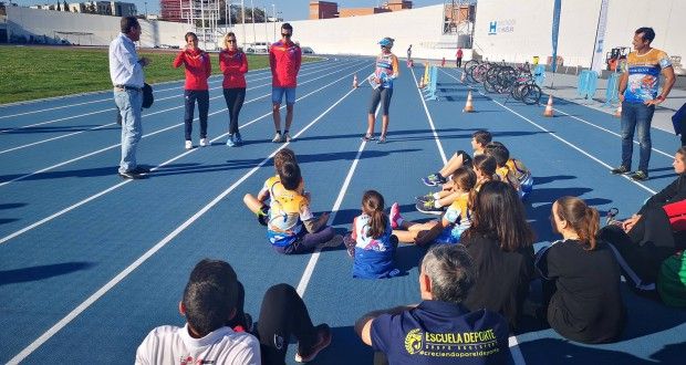 Sara Guerrero, Cecilia Santamaría y David Castro, con los jóvenes deportistas de Huelva